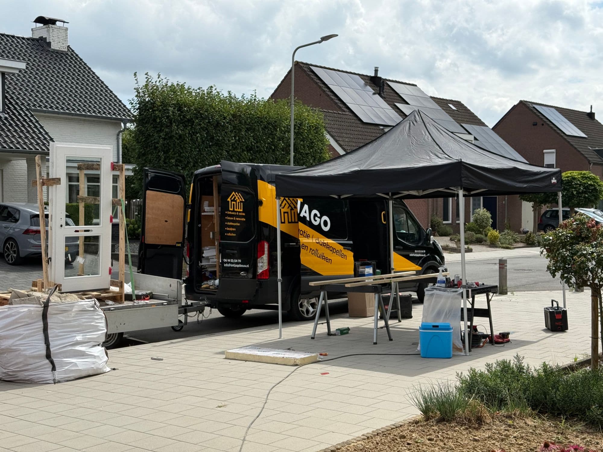De bedrijfsbus, werktent en aanhanger met kozijnen van Sintjago Kozijnen op locatie in Zuid-Limburg