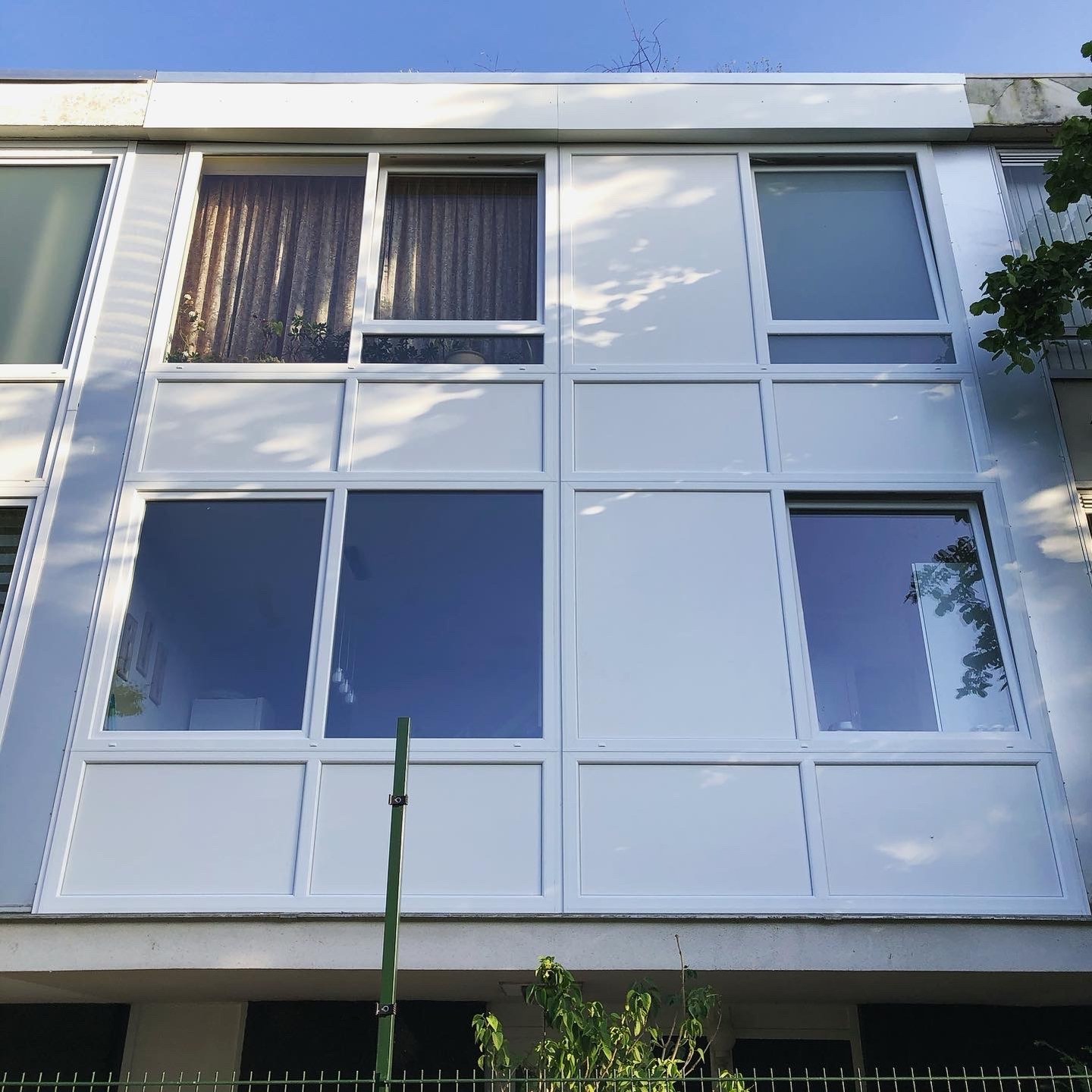 Dezelfde drive-in woning ná de renovatie: strakke nieuwe panelen en kozijnen